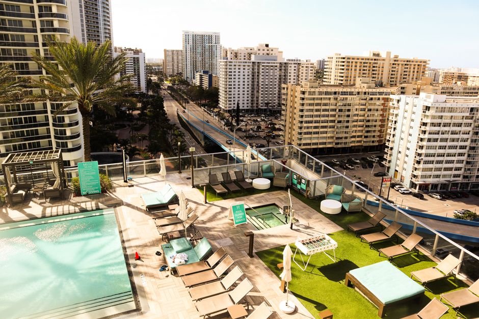 Aerial view of a luxurious rooftop pool area overlooking the vibrant downtown cityscape in Florida, USA.