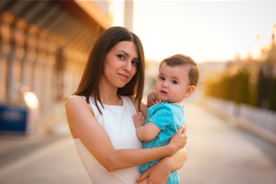 A heartwarming scene of a mother holding her child outdoors at sunset in Ankara, Türkiye.