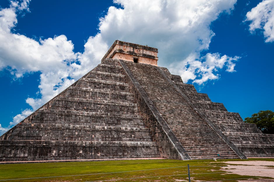 Impressive view of El Castillo pyramid against a vibrant blue sky at Chichén Itzá, Mexico.