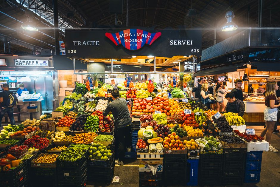Colorful market stall displaying fresh fruits and vegetables in Barcelona's bustling marke