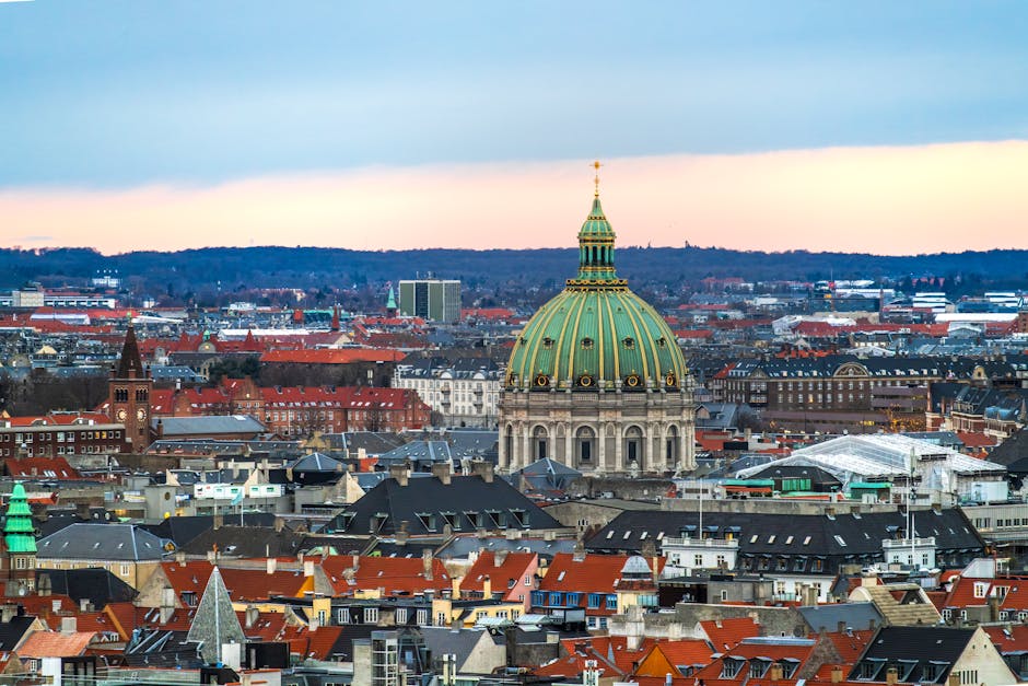 Stunning aerial view of Frederik's Church and Copenhagen skyline at sunset with iconic architecture.
