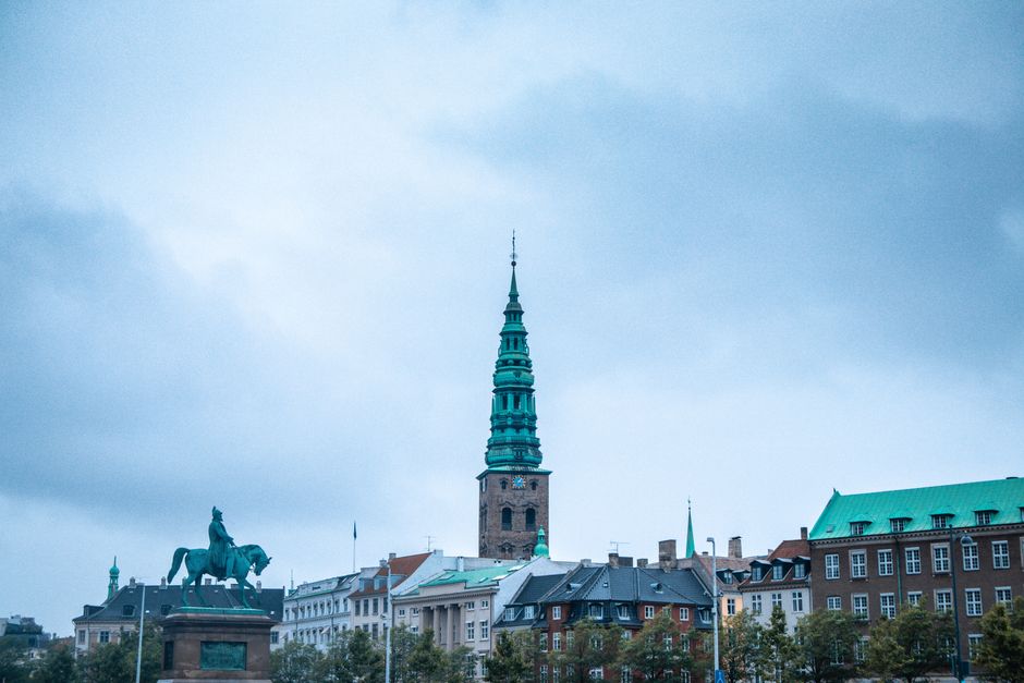 A stunning view of Copenhagen's landmark and surrounding architecture under a cloudy sky.