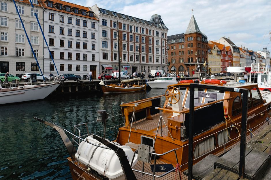 Explore the vibrant waterfront of Nyhavn Canal with historic buildings and moored boats.