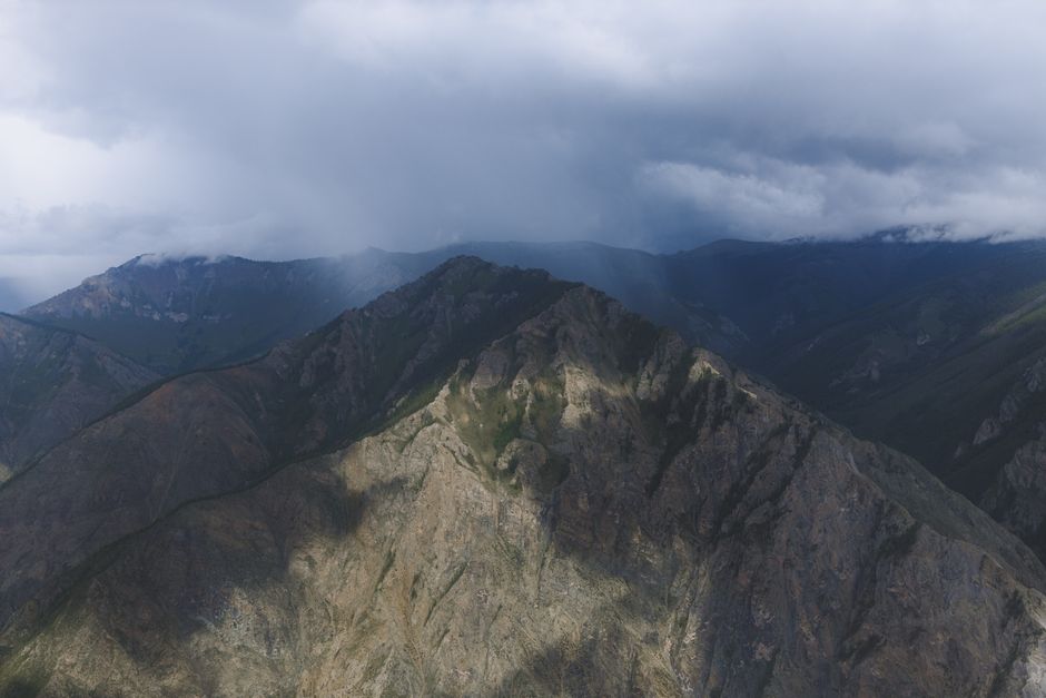 A breathtaking aerial view of rugged mountain peaks under a moody sky.