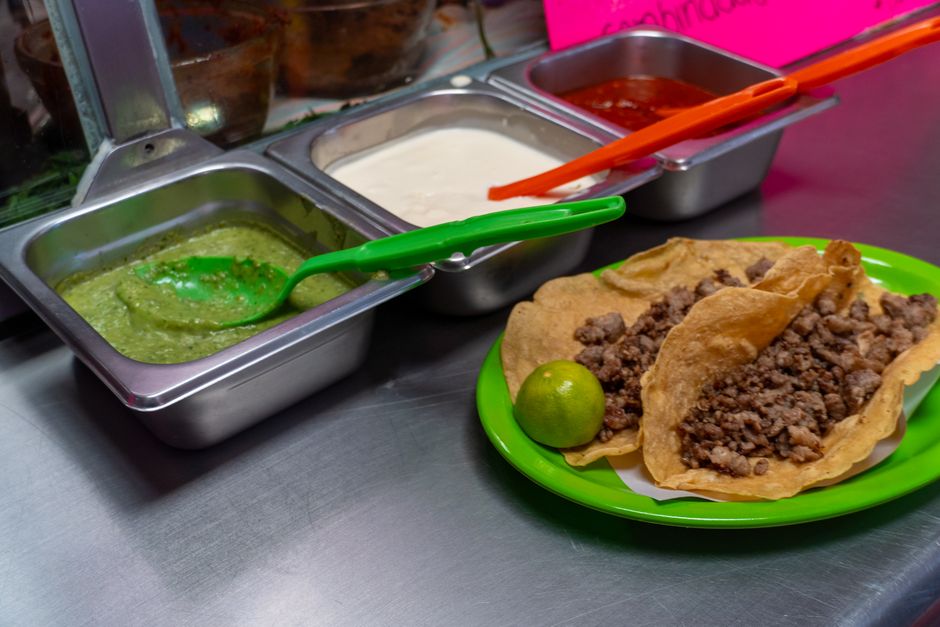 Delicious Mexican tacos with assorted salsas in a market setting. Captured in Mexico City.