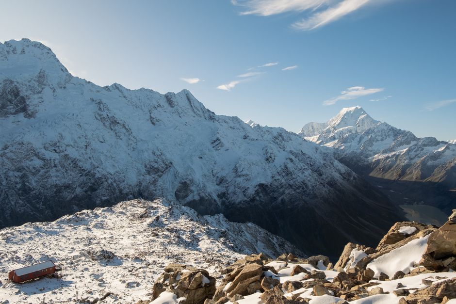 Stunning view of Aoraki Mount Cook and Mueller Hut in snow-covered New Zealand winter landscape.