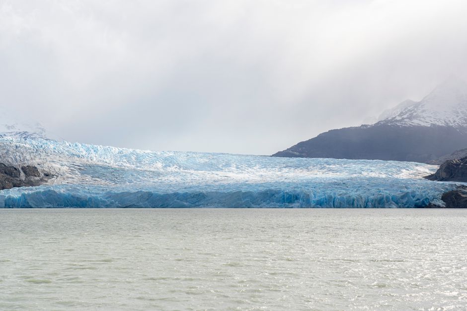Majestic glacier surrounded by mountains and lake in Torres del Paine, Chile.