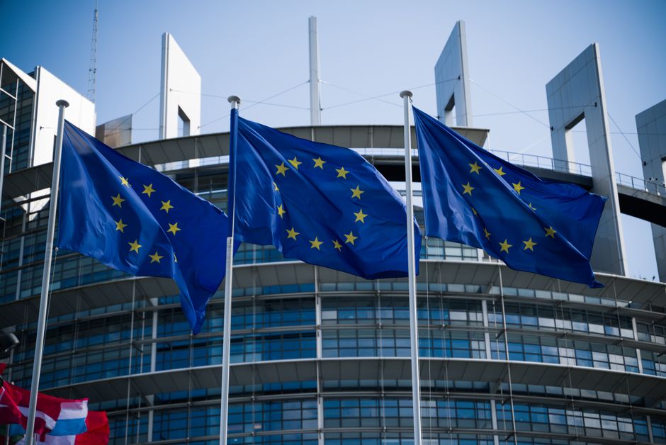 European Union flags waving outside the European Parliament in Strasbourg.