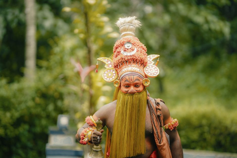 Theyam performer in elaborate costume and makeup, Kozhikode, Kerala, India.
