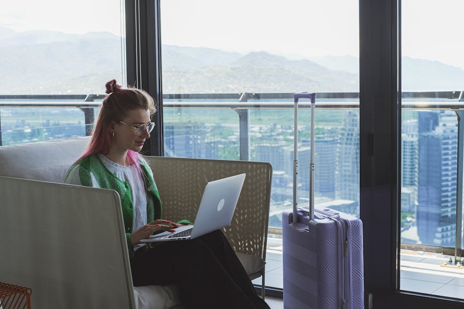 Woman working on a laptop in a hotel lounge with a stunning city view.
