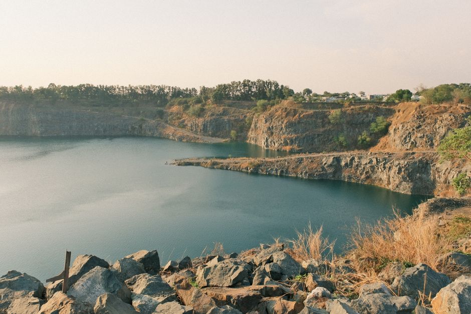 Peaceful view of a serene quarry lake surrounded by rocky cliffs and greenery.