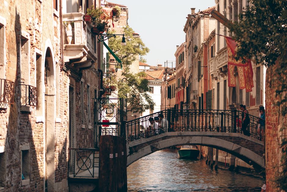 A captivating view of a Venetian canal with a historic footbridge and rustic architecture in Venice, Italy.