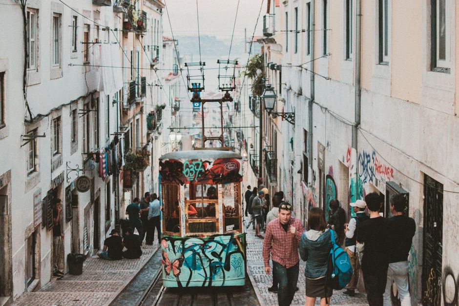 A lively urban view in Lisbon featuring a colorful tram and busy street.